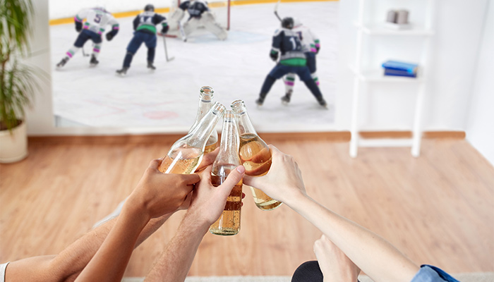 ​hockey players on the tv screens and a beer toast