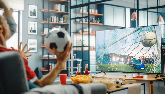 A man Watching soccer on the TV