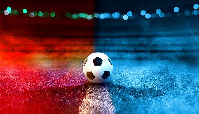 A black and white football standing in the middle of a red and blue field