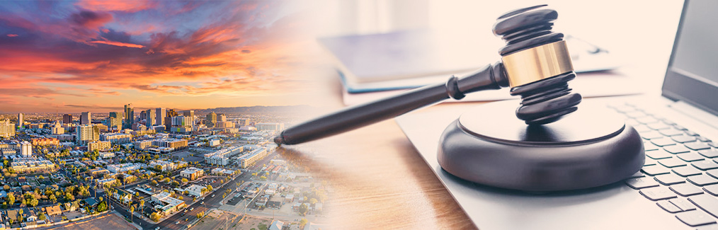 Phoenix skyline behind a judge's gavel, which rests on a laptop computer.