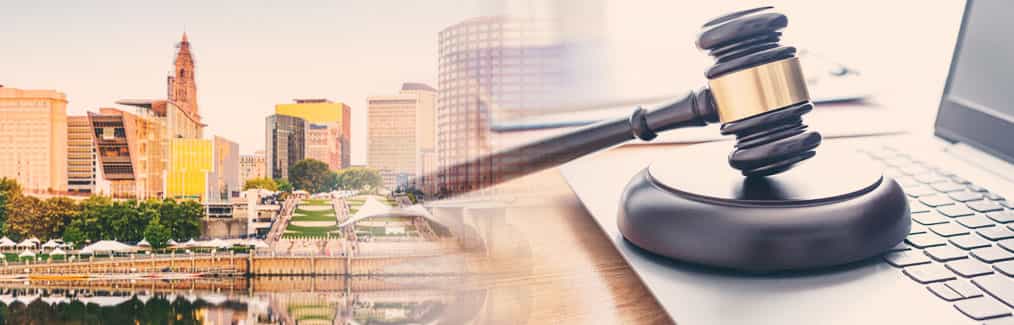 The Hartford skyline behind a judge's gavel, which rests on a laptop computer.