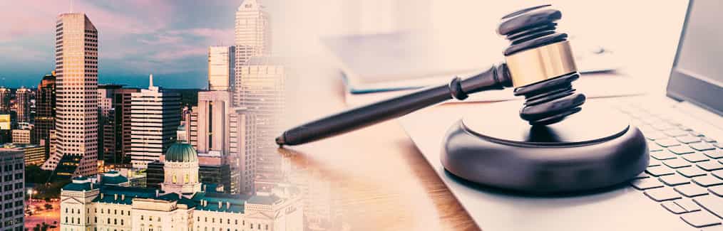 The Indianapolis skyline behind a judge's gavel, which rests on a laptop computer.