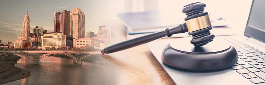 photograph of the skyline of the city of Columbus, a laptop, judge's gavel and block