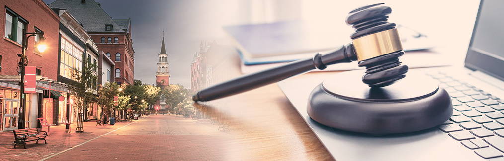 Montpelier streetscape behind a judge's gavel, which rests on a laptop computer.