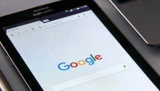 A smartphone shows Google's website