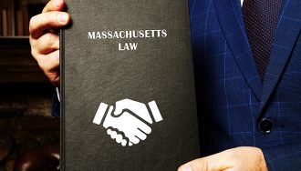 Massachusetts Law Book in the Hands of a Person in a Suit