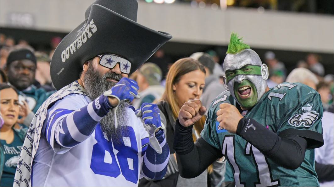 Two NFL fans playfully facing off in the stands at a game. by Nathan Whelan, April 30, 2025