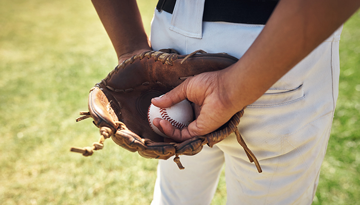 A man holding a baseball ball in a glove