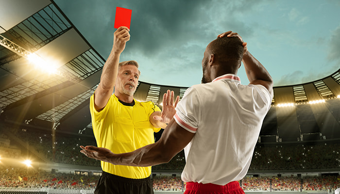 Soccer referee holding up red card