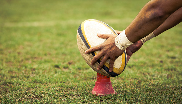A rugby ball on a tee on the pitch
