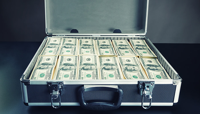 A suitcase with several bands of hundred-dollar bills
